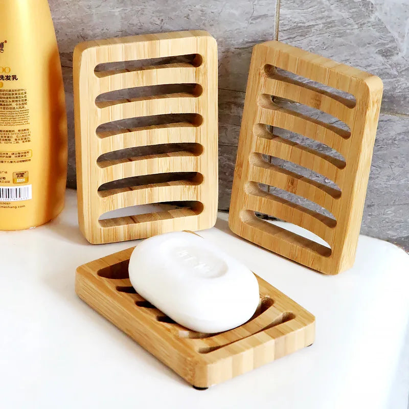 Draining Bamboo Soap Dish holding a white bar beside two upright bamboo trays