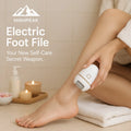 HighPeak Electric Foot File in white used on smooth heel with candles and towel for self-care at home