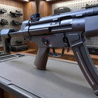Electric SMG Gel Blaster close-up showing the black receiver, trigger, selector, and curved magazine
