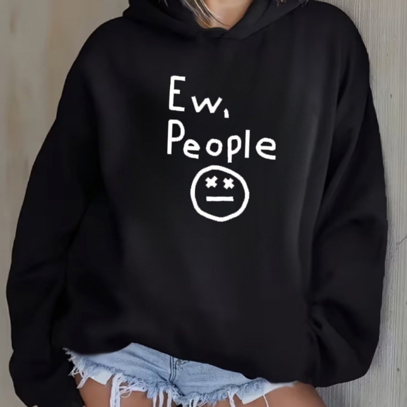 "Ew, People" Hoodie in black modeled from the front with the white statement graphic visible