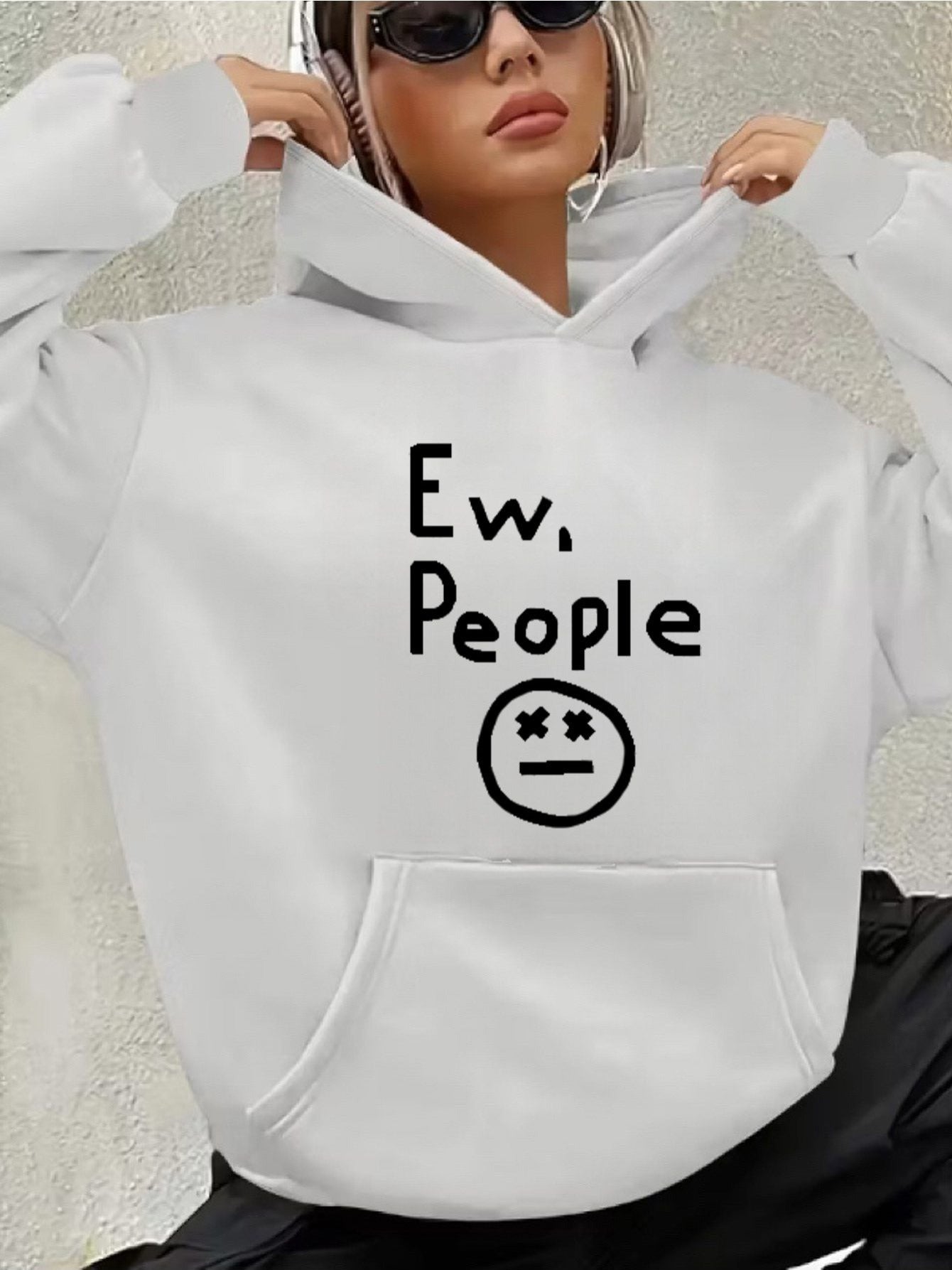 "Ew, People" Hoodie in white held by a model wearing sunglasses, showing the full front