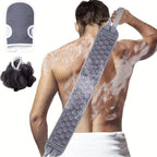 Gray back scrubber used across a man's back with the bath mitt and black loofah shown beside him