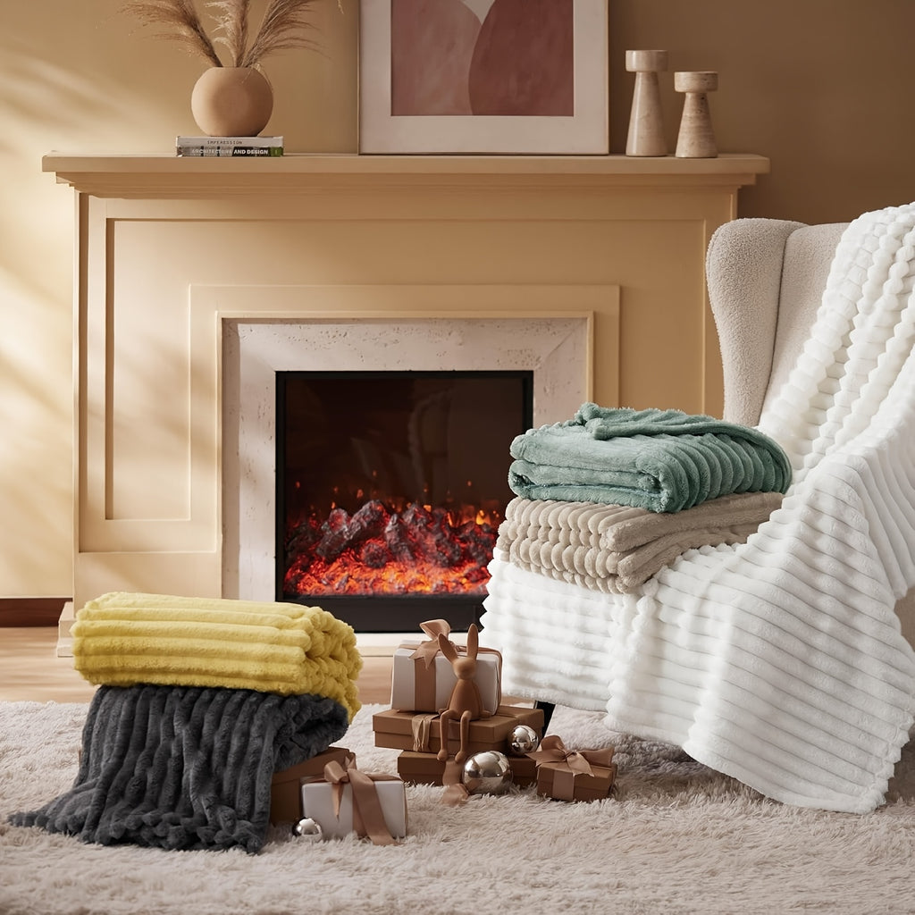 Cozy Fuzzy Blankets in white, yellow, gray and mint green stacked near fireplace with plush ribbed texture display