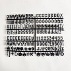 Felt Letter Board black replacement letter and symbol set arranged on its plastic sheet.