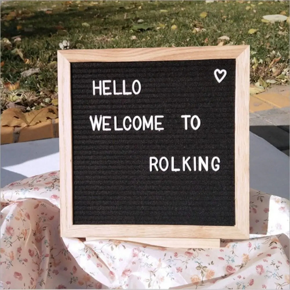 Felt Letter Board in black with a white welcome message displayed outdoors in its natural wood frame.