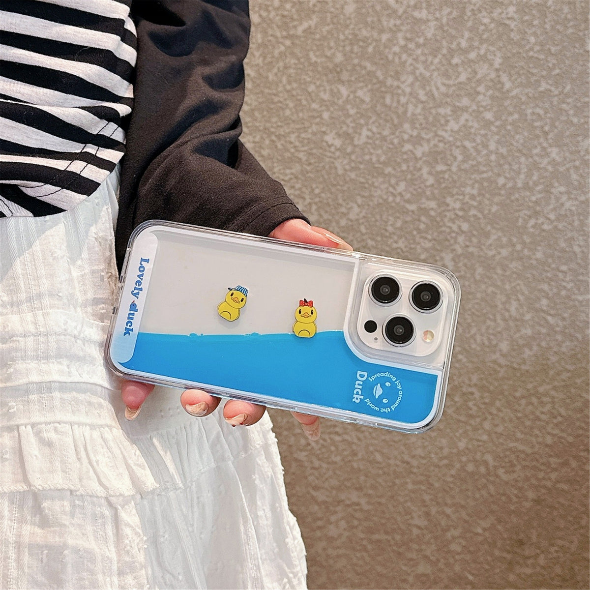 Floating Ducks Phone Case Hat Ducks case held sideways, showing blue liquid and separated duck pieces