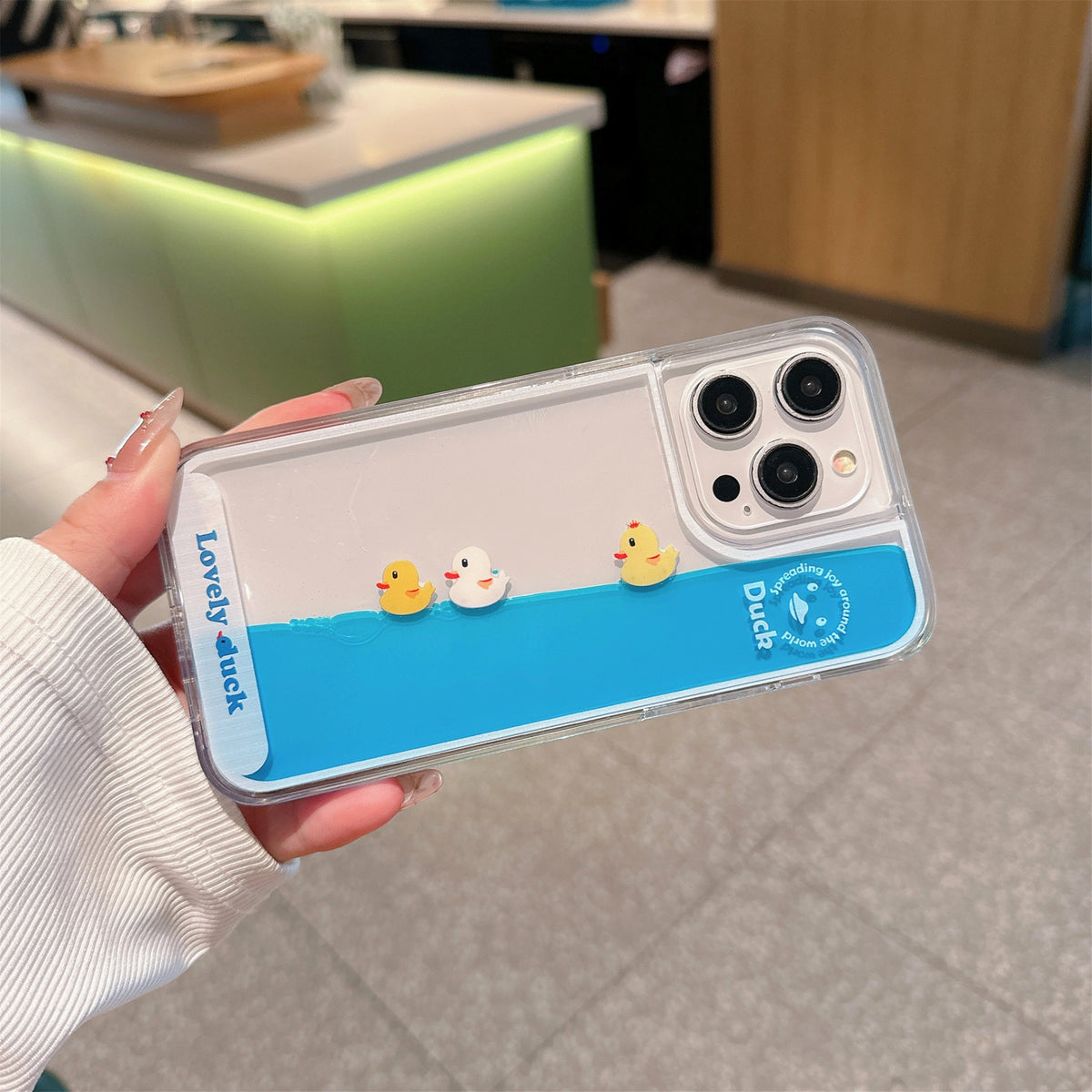 Floating Ducks Phone Case Three Ducks case tilted sideways, with blue liquid flowing along the long edge