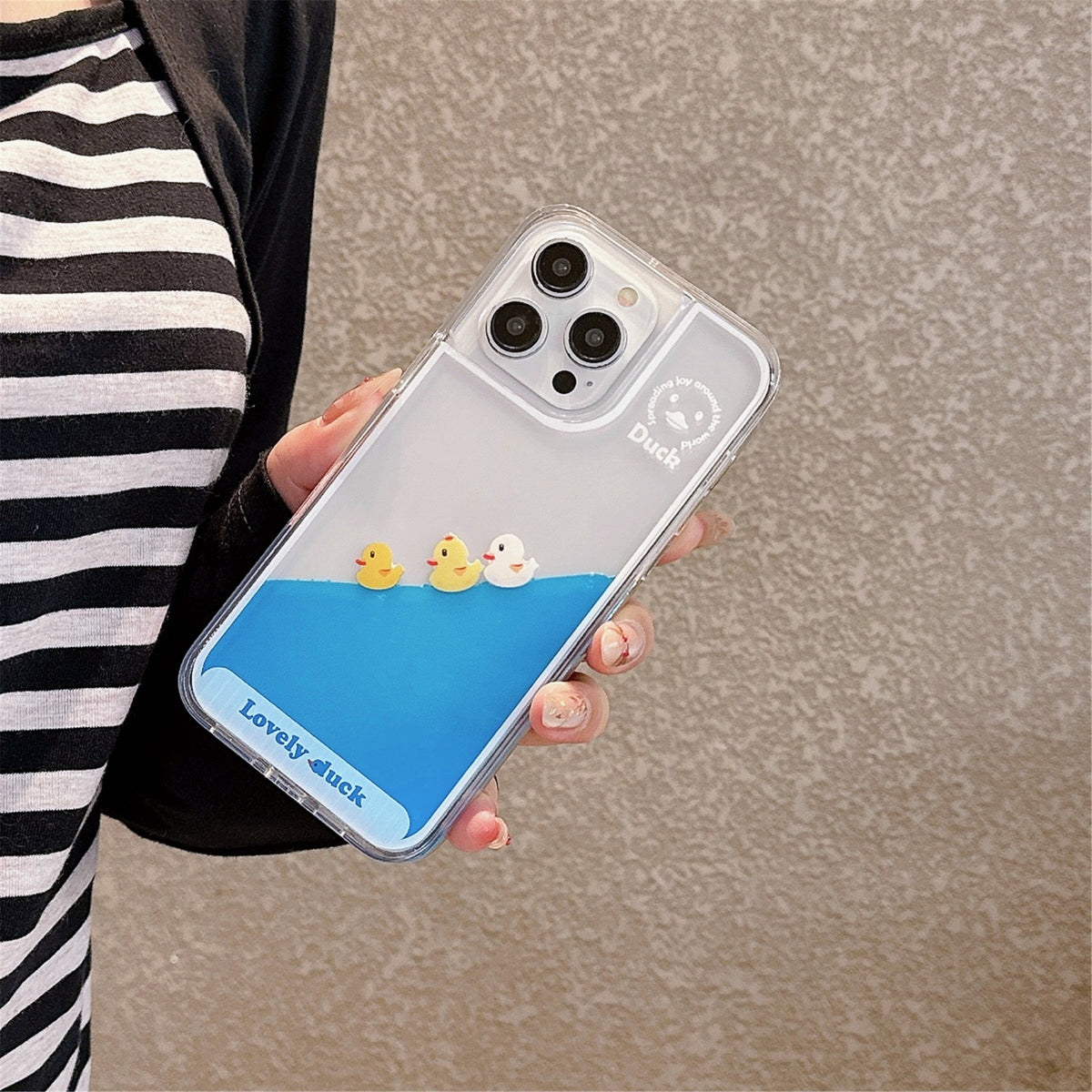 Floating Ducks Phone Case Three Ducks design held beside a black-and-white striped outfit