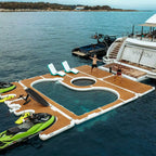 Floating Yacht Pool Dock connected beside a yacht with lounge chairs and watercraft around the deck