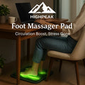 HighPeak Foot Massager Pad glowing green under feet of person sitting at desk, boosting circulation and relieving stress.
