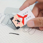 Funny Balding Man Erasers: A hand using the chef character to erase pencil marks on squared paper.