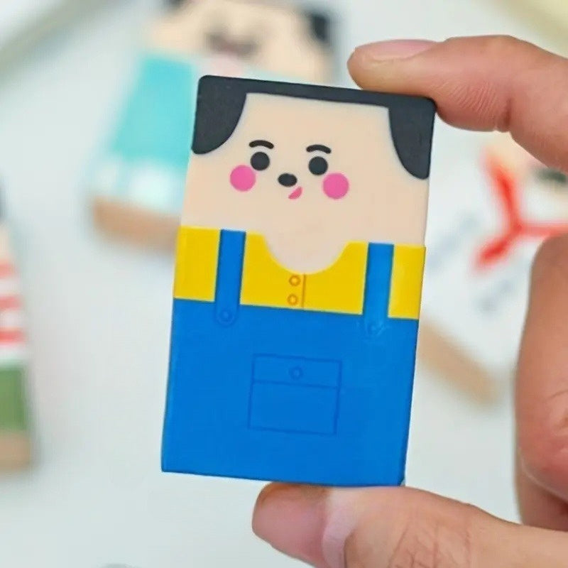 Funny Balding Man Erasers: Close-up of a blue-overalls character held between two fingers.