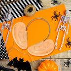 Funny Big Ears Headband on orange paper surrounded by skeletons, spiders and Halloween props