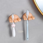Funny Feet Toothbrush Holders displayed side by side with white and blue manual toothbrushes