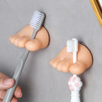 Funny Feet Toothbrush Holders gripping two manual toothbrush handles in the toe-shaped clips