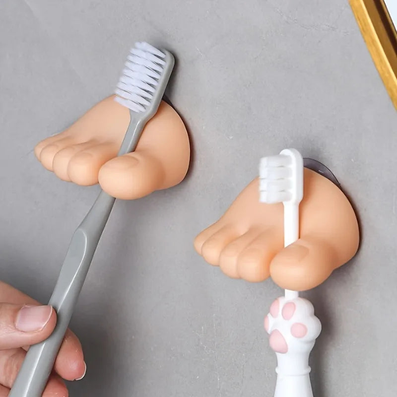 Funny Feet Toothbrush Holders gripping two manual toothbrush handles in the toe-shaped clips