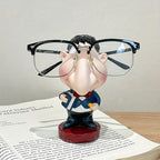 Funny Teacher Glasses Stand displaying black eyeglasses while standing on an open book