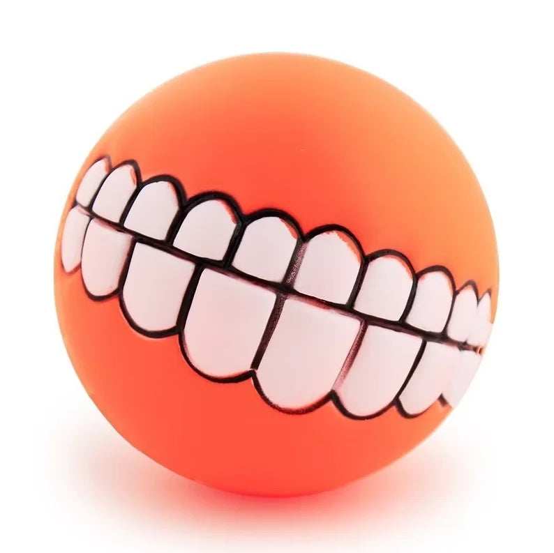Funny Teeth Dog Balls orange ball close-up on a white background with its cartoon smile.