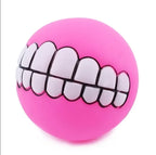 Funny Teeth Dog Balls pink ball close-up showing white cartoon teeth outlined in black.