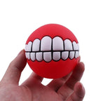 Funny Teeth Dog Balls red ball held in a hand, showing its round shape and novelty teeth.