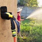 Garden Hose Nozzle Holder in black mounted outdoors with a yellow and black spray nozzle stored inside