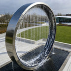 Garden Ring Waterfall Fountain viewed at an angle in daylight, with falling water above a dark rectangular pool