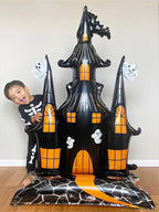 Giant Haunted House Balloon beside a child in a skeleton costume to demonstrate its oversized scale