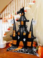 Giant Haunted House Balloon displayed beside a staircase with pumpkins and Halloween cobweb decorations