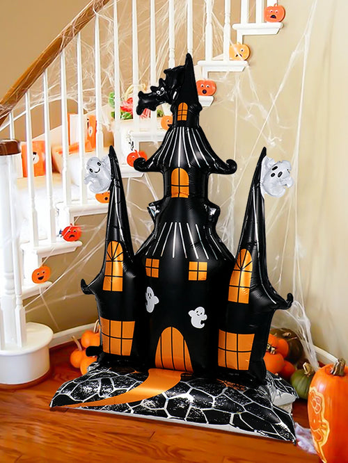 Giant Haunted House Balloon displayed beside a staircase with pumpkins and Halloween cobweb decorations