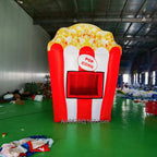 Front view of the giant inflatable popcorn stand showing red and white stripes and the rectangular serving window.