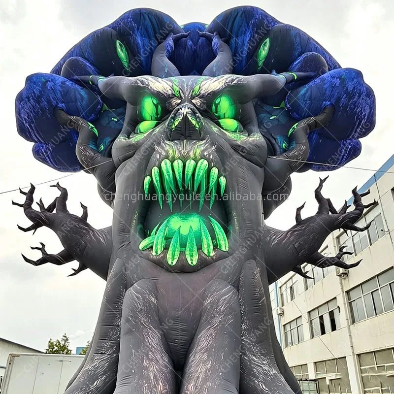 Close-up of the inflatable tree monster face with green eyes and pointed green teeth