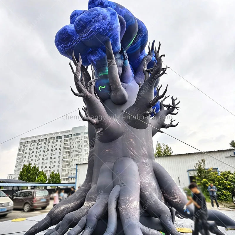 Rear side view of the inflatable tree monster outdoors with people nearby for scale