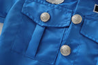 Girls Police Costume Set close-up of blue chest pockets, stitching, and embossed silver-colored buttons.