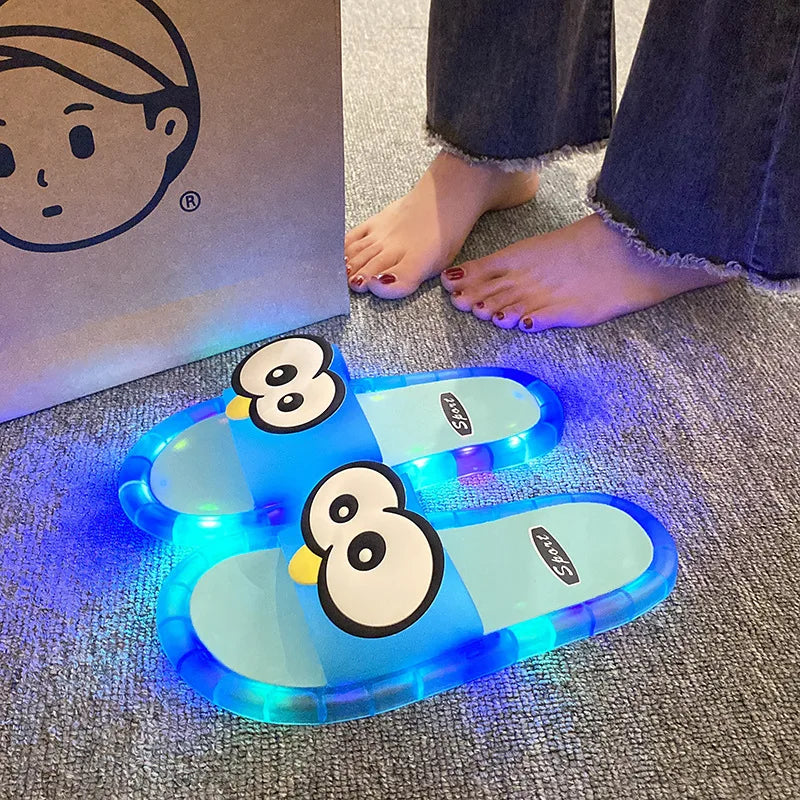 Blue Glowing Googly Eye Slides with multicolor glowing soles on carpet beside a person's feet