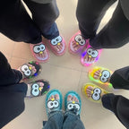 Five people wearing pink, yellow, blue and black Glowing Googly Eye Slides in a circle