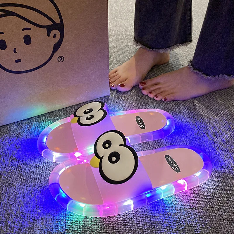Pink Glowing Googly Eye Slides with multicolor glowing soles on carpet beside a person's feet