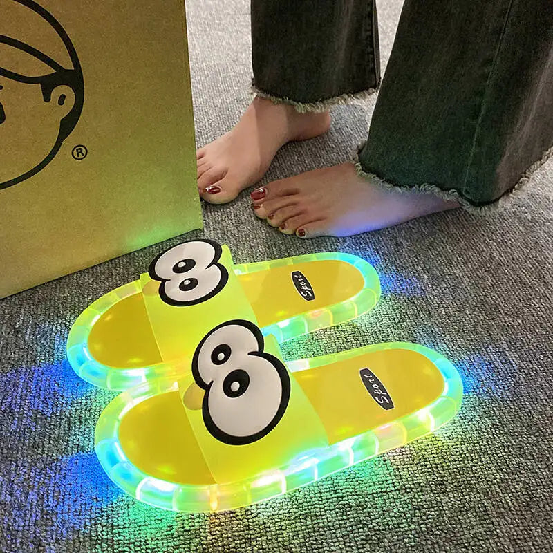 Yellow Glowing Googly Eye Slides with multicolor glowing soles on carpet beside a person's feet