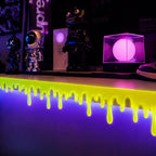 Glowing Slime Shelf Drips — Yellow-green drips lining a collectible display shelf under purple lighting.