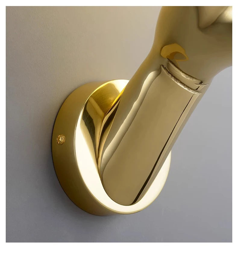 Golden Hand Wall Lamp — Close-up of the gold wrist and round wall-mounting base