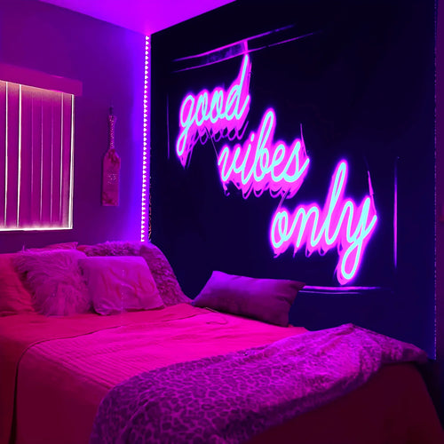 Good Vibes Only Tapestry with pink and blue lettering above a bed in a purple-lit room