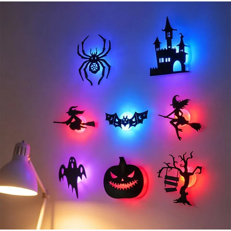 Halloween 3D Wall Lights in an eight-design arrangement beside a desk lamp, with vivid blue and red glows.