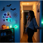 Halloween 3D Wall Lights in an entryway as a woman opens the door, alongside other Halloween decorations.