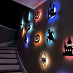Halloween 3D Wall Lights viewed along a staircase, showing colored halos behind castles, pumpkins and a spider.