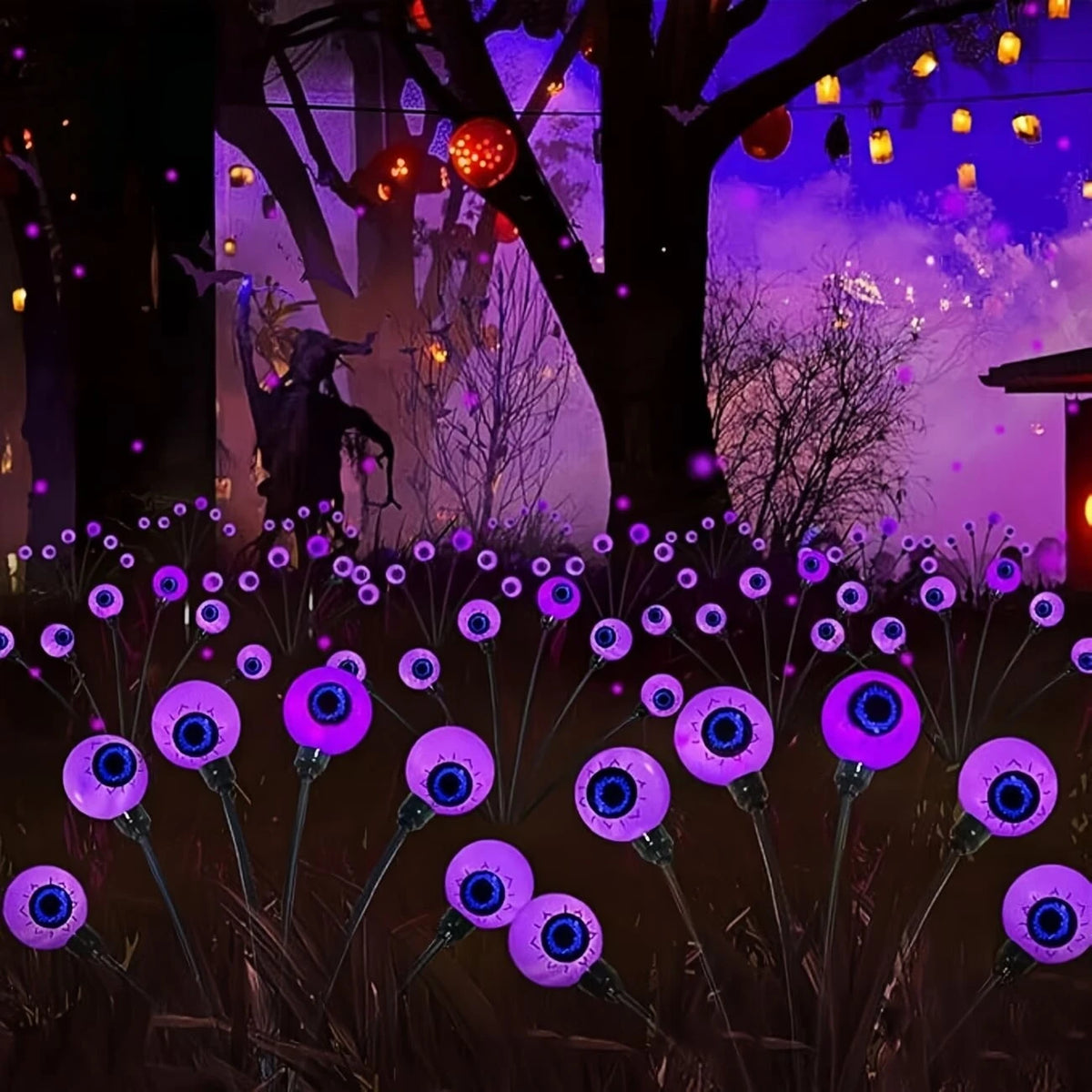 Purple Halloween eyeball stake lights in a spooky garden scene with hanging lanterns