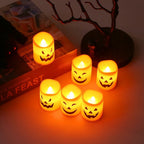 Halloween Pumpkin LED Candle Set: overhead view of six glowing candles beside books and a decorative tree.