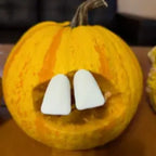 Halloween Pumpkin Teeth Inserts forming two large buck teeth in a small yellow pumpkin