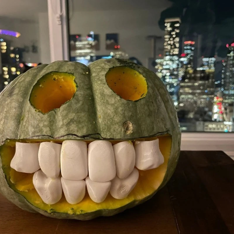 Halloween Pumpkin Teeth Inserts round style forming a full grin in a green pumpkin by a city-view window