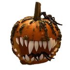 Halloween Pumpkin Teeth Inserts sharp fangs in a textured orange pumpkin decorated with black spiders