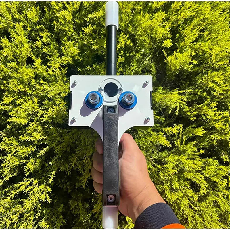Handheld Wire Puller with black handle held upright outdoors against green foliage.
