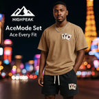 HighPeak AceMode Set featuring brown graphic tee and black shorts with card patch detail in vibrant city night setting